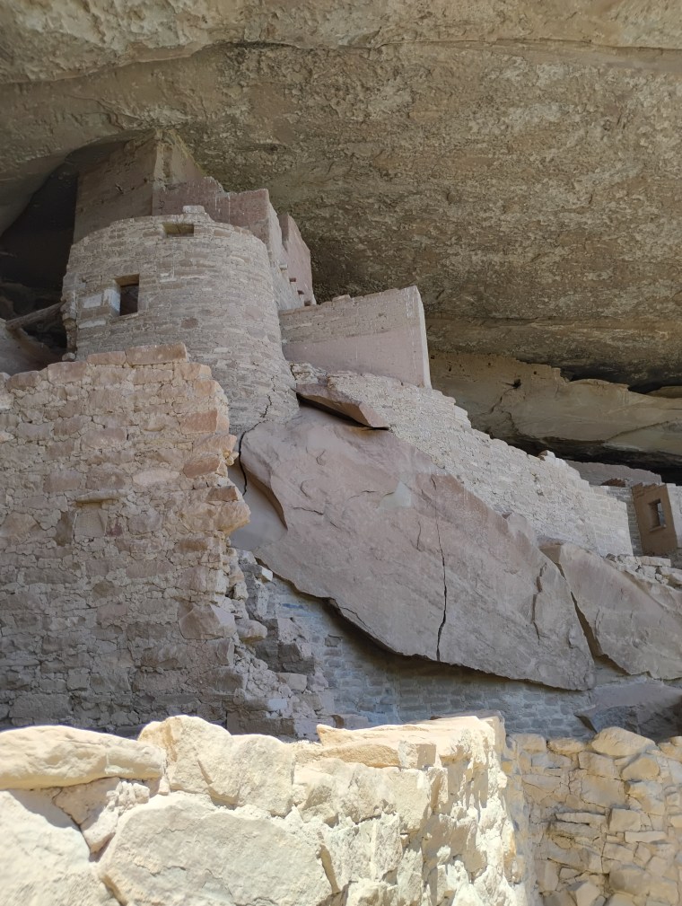 An ancient building of weathered stone looms above. Detail of Cliff House. Photo by Deby Fredericks 2026